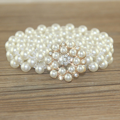 เข็มขัดมุกสีขาว หัวเข็มวงกลมแฉกสีทองแต่งด้วยคริสตรัลใสและมุกสีขาว สายเข็มขัดไขว้ 2 สาย